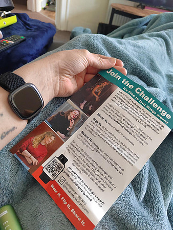 A woman wearing her watch inside the wrist reads a leaflet about the Insider Watch Challenge