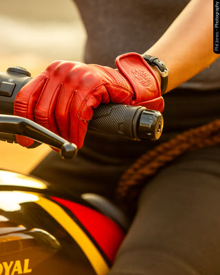 detailed photo of motorcycle gloves as a female rider grips the handle bars