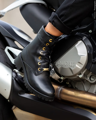 woman wears motorcycle boots sitting on a Ducati motorcycle